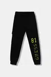Dětské bavlněné tepláky Guess černá barva, s potiskem, L5YQ13 KAD74