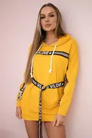 Šaty zdobené páskou s nápisy hořčice