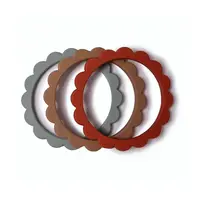 Mushie náramkové hryzátko zo silikónu FLOWER - Cambridge Blue / Clementine / Natural