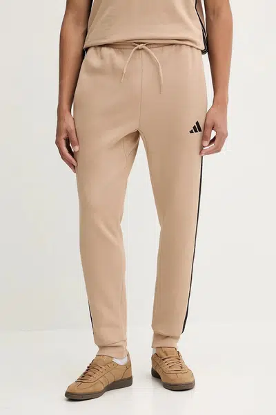 Tepláky adidas Essentials pánské, béžová barva, s aplikací, JX0712